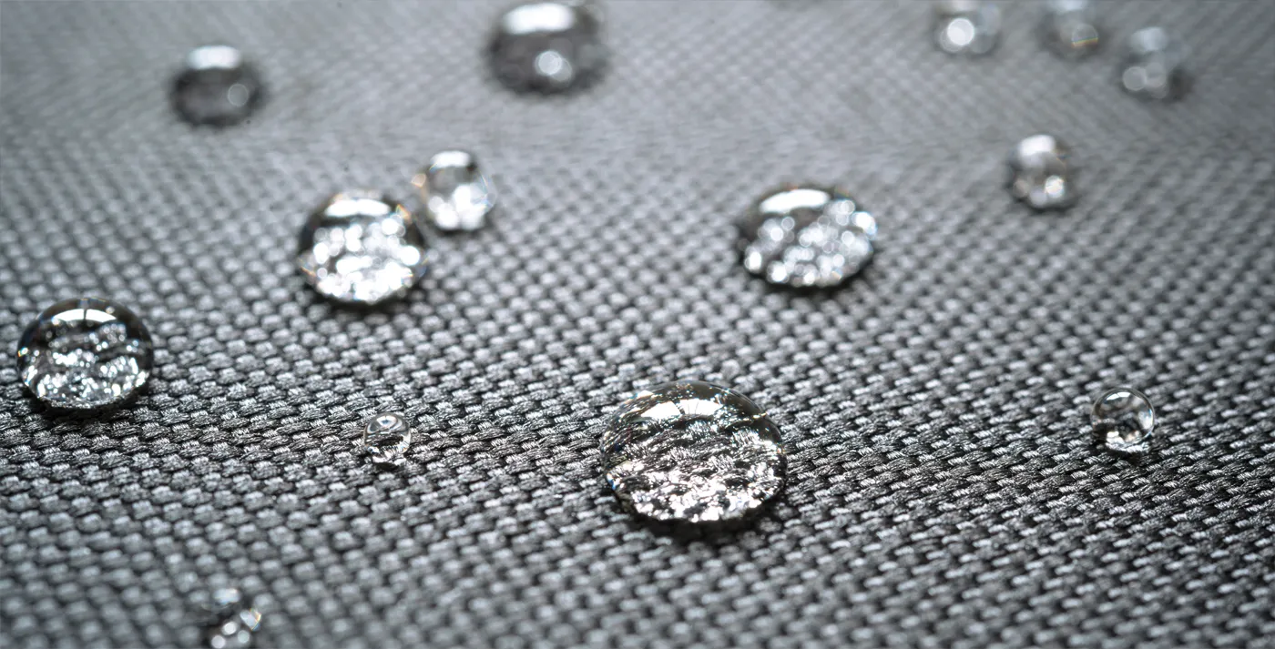 Technician applying fabric protection to a sofa